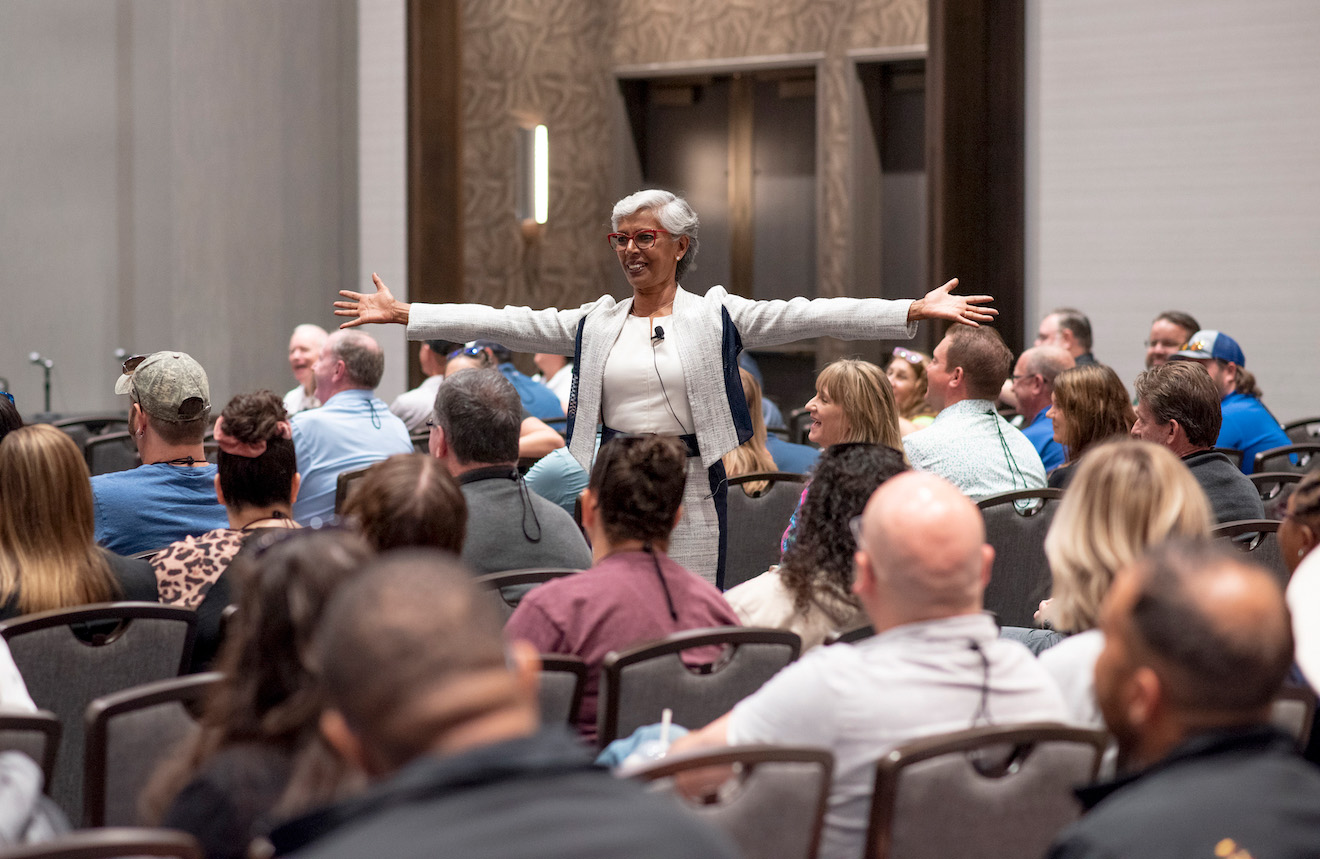 smiling woman with open arms at WWA education session